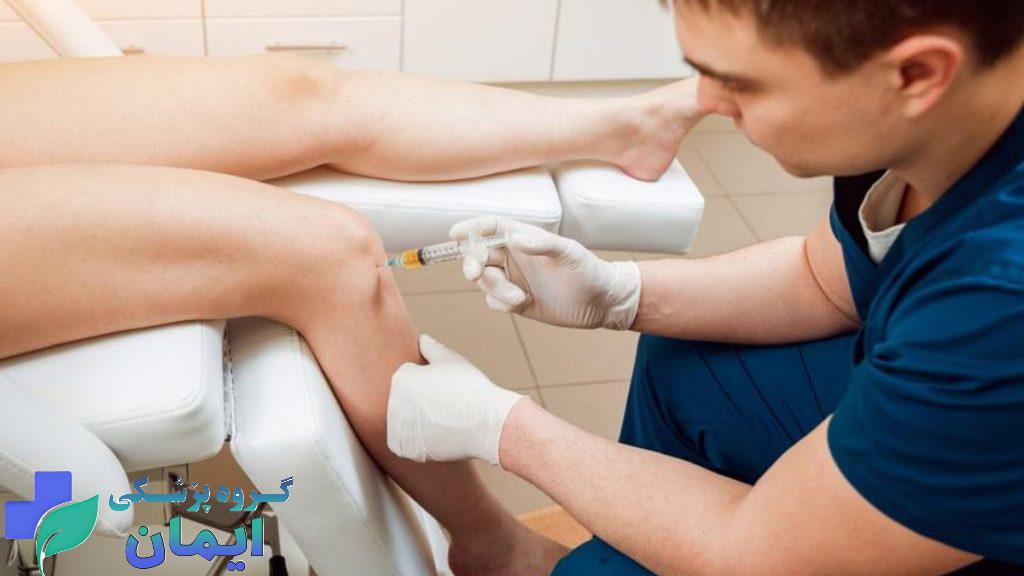 پزشک در حال تزریق آمپول هیالورونیک اسید به زانوی بیمار به منظور رفع درد و التهاب